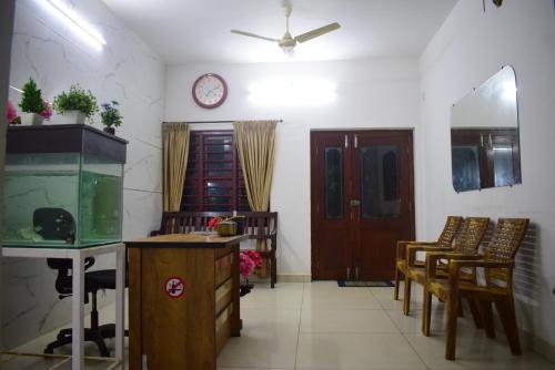 a living room with a fish tank and a clock on the wall at BEACH faceing rooms with private beach in Kalyānpur