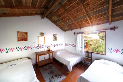 1 dormitorio con 2 camas y ventana en Hotel Taselotzin, en Cuetzalán del Progreso