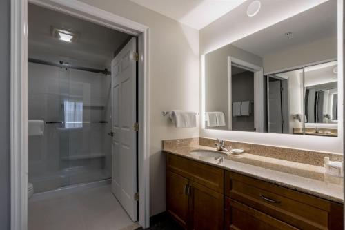 a bathroom with a shower and a sink and a mirror at Residence Inn by Marriott Halifax Downtown in Halifax