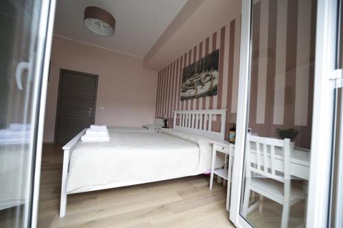 a bedroom with a white bed and a mirror at Casa di Paola in Palermo