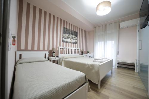 a hotel room with two beds and a window at Casa di Paola in Palermo