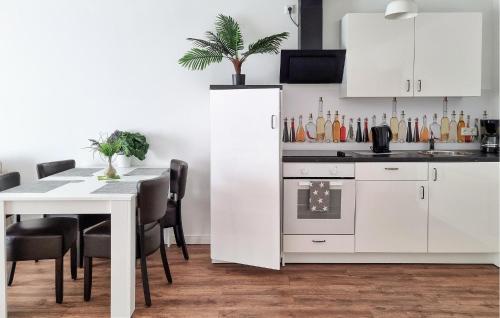 a kitchen with white cabinets and a table with chairs at Pet Friendly Apartment in Zahren