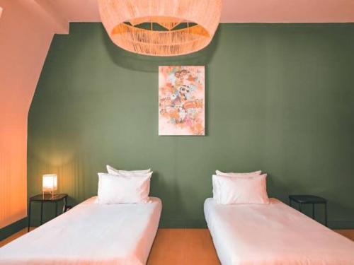 - 2 lits dans une chambre dotée d'un mur vert dans l'établissement Grand Appartement 8 personnes, à Mulhouse