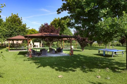 a gazebo with tables and benches in a park at Agriturismo Il Brugnolo in Scandiano