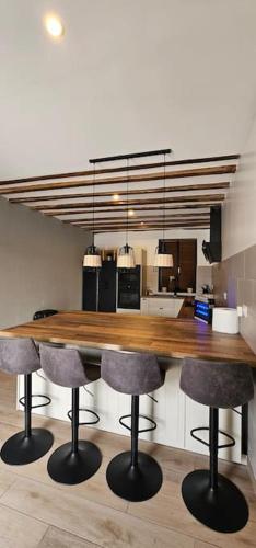 - une cuisine avec un comptoir en bois et des tabourets de bar dans l'établissement L’instant évasion, à Saint-Rémy-Blanzy