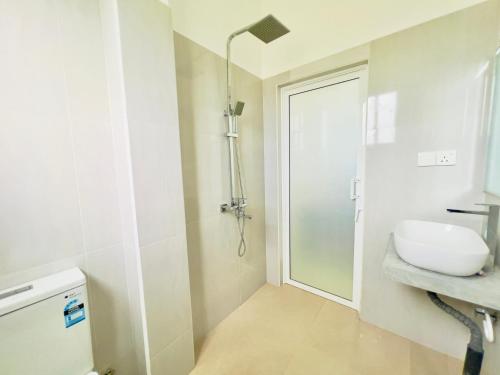biała łazienka z umywalką i prysznicem w obiekcie Lavish Weligama w mieście Weligama