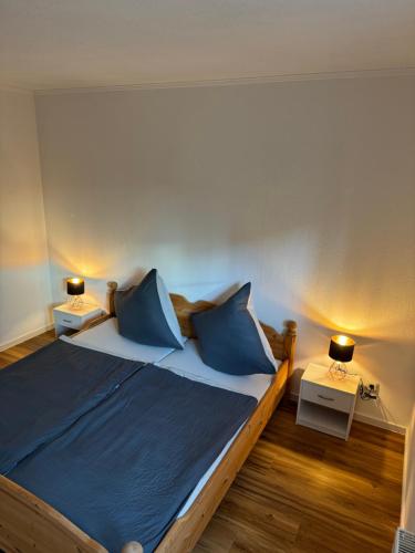 a bedroom with a large bed with blue pillows at Adenauer Forst Ring Apartment in Adenau