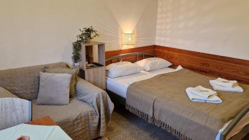 um quarto de hotel com duas camas e um sofá em Apartmani Fučkar em Krapinske Toplice