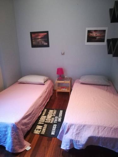 ein Schlafzimmer mit zwei Betten und einem Tisch mit Lampe in der Unterkunft Mina’s Villa, 200m from the beach in Porto Rafti