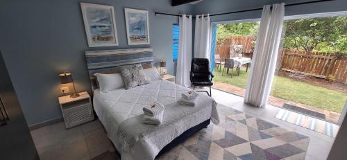 a bedroom with a bed and a view of a yard at Island Flip Flop Holidays in Sedgefield