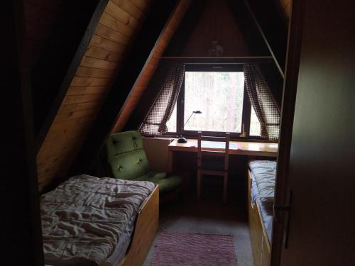 a attic room with a bed and a window at Ferienhaus Angret Winkel in Meißendorf