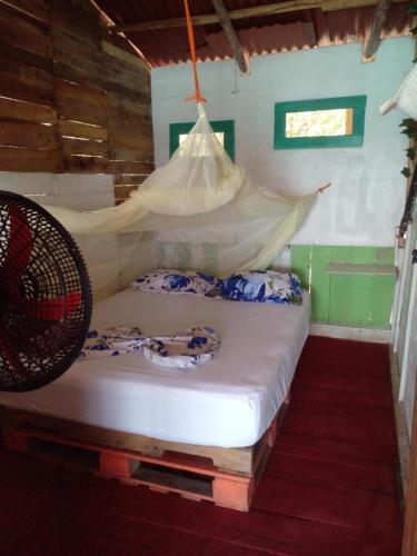 a bedroom with a bed with a mosquito net at DespertArte espacio de Arte y Hospedaje in Playa Blanca