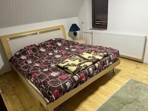 a bedroom with a bed with a comforter on it at Mountain Vila in Ponikva in Kochani