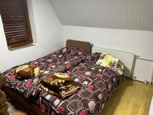 a bed with blankets and pillows in a room at Mountain Vila in Ponikva in Kochani