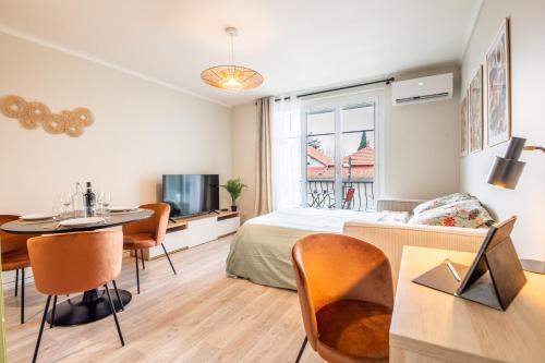 une chambre avec un lit, une table et des chaises dans l'établissement Au calme de L'Iris - Clim - Garage - Wifi - Tramway, à Avignon