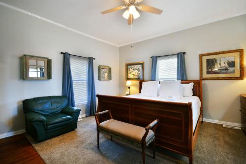 - une chambre avec un lit, une chaise et un ventilateur dans l'établissement Comfy Cottage: Minutes from Main St, Private Yard, à Greenville