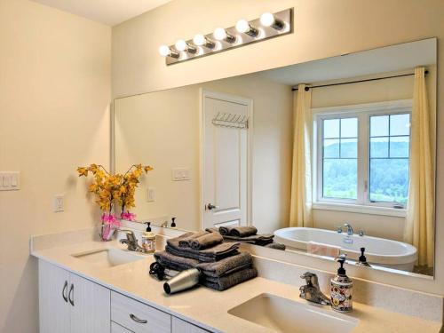 uma casa de banho com 2 lavatórios e um espelho grande em Water's Edge Haven em East Gwillimbury