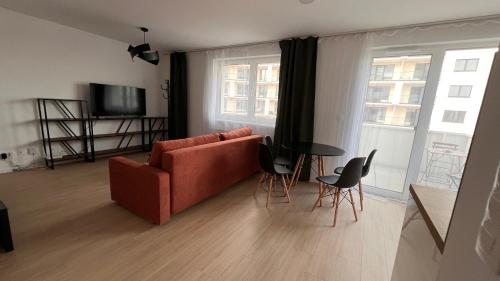 ein Wohnzimmer mit einem Sofa, einem Tisch und Stühlen in der Unterkunft 2 room Apartment with terrace, new building, B1 in Bratislava