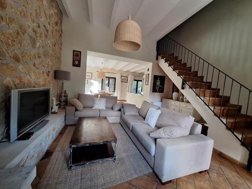 a living room with a couch and a tv at El Pinar de la Lobera in La Matea