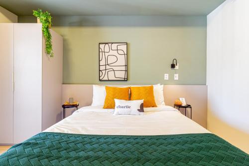 1 dormitorio con 1 cama grande con almohadas de color naranja en House of Charlie Pinheiros, en São Paulo