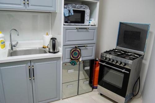 a small kitchen with a stove and a microwave at شقق نرمادا المفروشة فرع قباء in Al Madinah