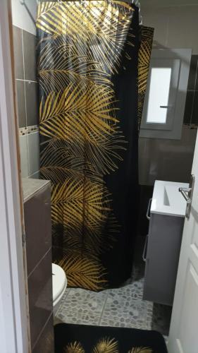 uma casa de banho com uma cortina de chuveiro preta e dourada em Le first em Grasse