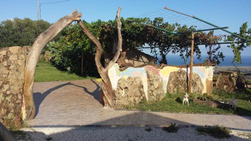 an archway in a stone wall with a dog standing next to it at Agriturismo Irghitula in Posada