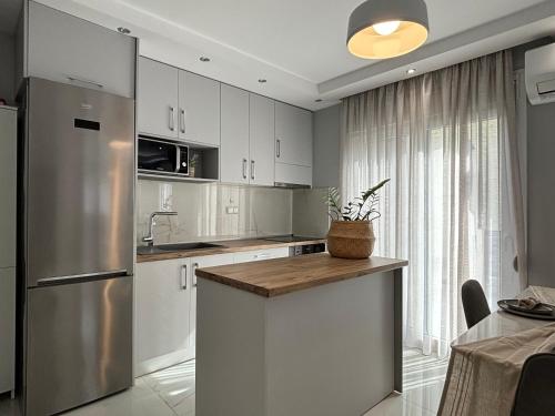 a kitchen with white cabinets and a stainless steel refrigerator at Domi Luxury in Kavala