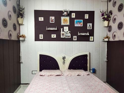 a bedroom with a bed and pictures on the wall at OYO Home Abhishek Homestay in Pathānkot