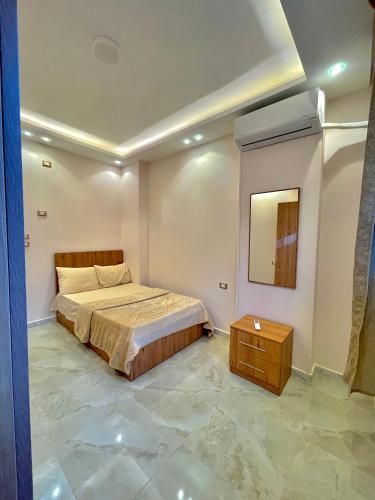 Un dormitorio con una cama y una mesa. en MASA HOTEL APARTMENT en Mansoura