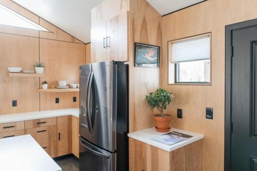 a kitchen with a stainless steel refrigerator and wooden cabinets at Tour de Fruita & EV charge point in Fruita