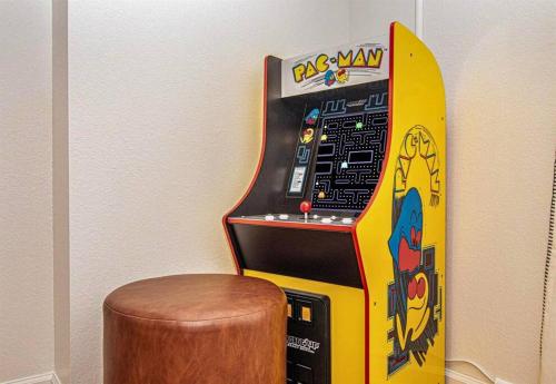 a claw machine with a skateboard next to a stool at Willow Trace: Family Retreat, Hot Tub, Gaming! in Pigeon Forge