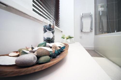 a bowl of rocks on a counter in a bathroom at Penarth Stunning Seaside Apartment, Pets welcome, Free wifi and Parking, Sleeps 8! in Cardiff