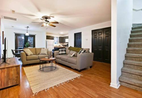 a living room with two couches and a staircase at Willow Trace: Family Retreat, Hot Tub, Gaming! in Pigeon Forge