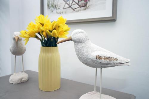 two birds and a yellow vase with yellow flowers at Coastal penarth dream! Close to Cardiff superb location near bars and restaurants! Dog friendly and welcome breakfast pack! in Cardiff