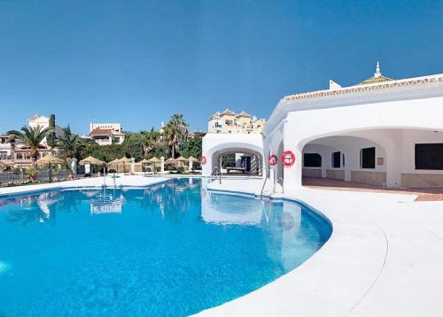 a swimming pool with blue water in a resort at Stunning Duplex in Capistrano Playa, Nerja in Nerja