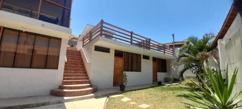 a house with a staircase in front of it at LA COLINA Casa-Hospedaje in Máncora