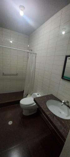 a bathroom with a toilet and a sink at LA COLINA Casa-Hospedaje in Máncora