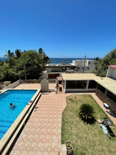 a house with a swimming pool next to the ocean at LA COLINA Casa-Hospedaje in Máncora