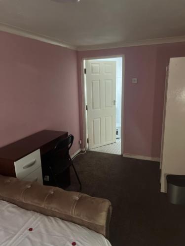 Habitación con cama, escritorio y puerta. en Private Room in Basildon en Vange
