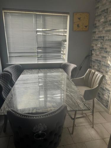 a glass table and chairs in a room with a window at Private Room in Basildon in Vange