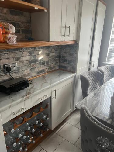 una cocina con una barra con un montón de botellas de vino en Private Room in Basildon en Vange