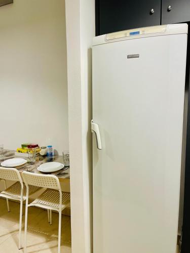 frigorifero bianco in cucina con tavolo di Hostel Green World a Novi Sad