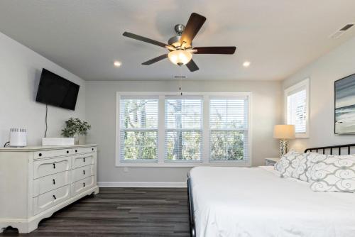 a bedroom with a white bed and a ceiling fan at Three Minute walk to the Beach in Virginia Beach