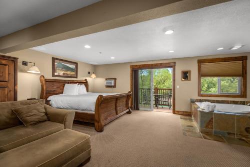 a bedroom with a bed and a tub in a room at Duck Inn Lodge in Whitefish