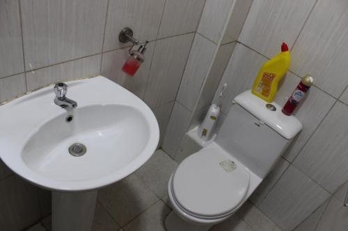 een badkamer met een wastafel en een wit toilet en een wastafel bij ChabaA5SQ in Nairobi