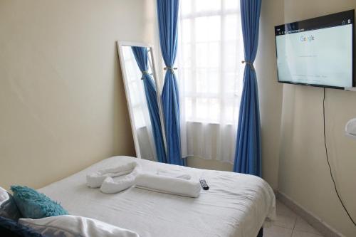 een slaapkamer met een bed en een flatscreen-tv bij ChabaA5SQ in Nairobi