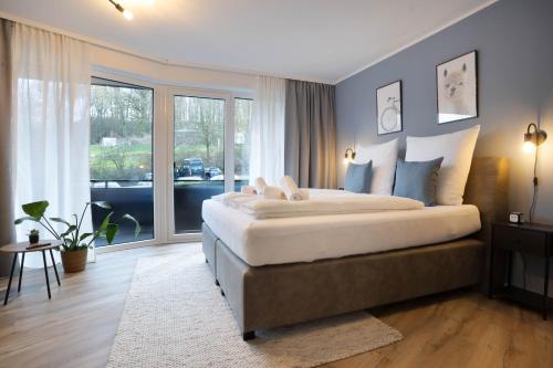 a bedroom with a large bed and a large window at NSV-Apartments am Waldrand in Bad Essen