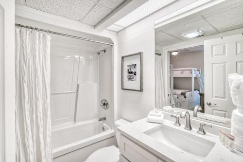 a white bathroom with a tub and a sink and a mirror at Hp 422 Blue Haven in Rosemary Beach