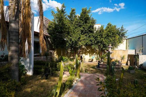 einen Garten mit Palmen und einem Ziegelweg in der Unterkunft Casa Mer, el oasis de la música y el agua in Tequisquiapan